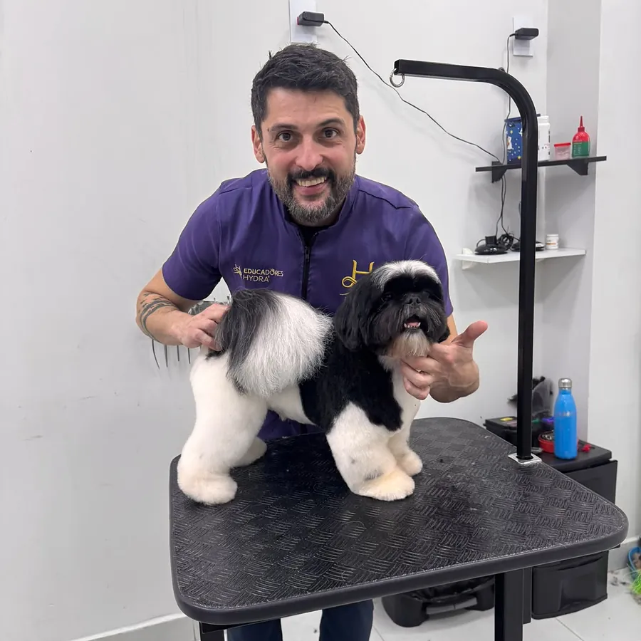 Vinícius com um Shih-tzu preto e branco na bancada